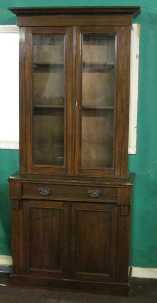 A 19th Century mahogany bookcase on cabinet the upper section  with moulded cornice, the interior fitted adjustable shelves and  enclosed by glazed panelled doors, the base fitted 1 long drawer  above a double cupboard, raised on a platform base 35"