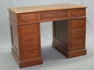 An oak kneehole pedestal desk with inset tooled leather writing  surface above 1 long and 8 short drawers 42"