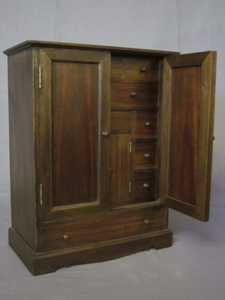 A 19th Century style mahogany "apprentice" cabinet, the interior fitted numerous drawers and a cupboard enclosed by panelled  doors, the base fitted 1 long drawer raised on a platform base  13"