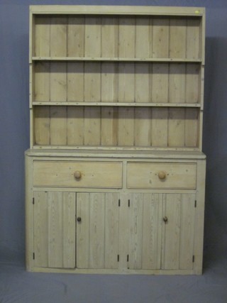 A Victorian stripped pine dresser with raised back fitted 3  shelves, the base fitted 2 long drawers above a double cupboard  54"