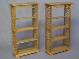 A pair of 19th Century style rectangular bleached mahogany bookcases with adjustable shelves and fret work decoration to the  sides, fitted adjustable shelves 20"