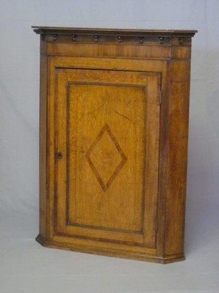 A Georgian oak corner cabinet with moulded cornice, the interior fitted shelves enclosed by a panelled door 34"