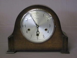 A 1930's 8 day chiming mantel clock with silvered dial and  Roman numerals contained in an arch shaped case