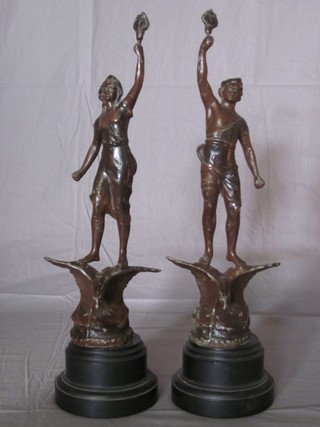 A pair of French Art Deco spelter figures in the form of standing lady and gentleman with torch 12"