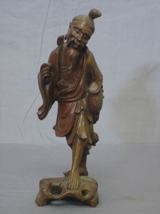 A carved root wood figure of a standing sage 9"