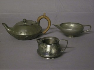 A planished pewter cream jug, a plain pewter cream jug and a  pewter teapot