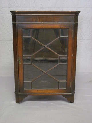 A Georgian style mahogany hanging corner cabinet with moulded cornice, the interior fitted shelves enclosed by astragal glazed  doors, raised on bracket feet 22"