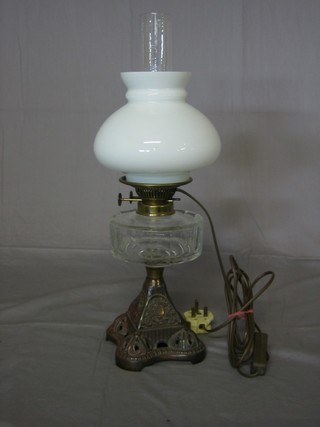 A Victorian oil lamp with glass reservoir and chimney, raised on  a pierced iron stand, converted for use as an electric table lamp  21" ..e324