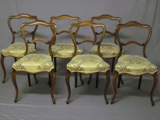 A set of 6 Victorian rosewood spoon back dining chairs with carved mid rails, the seats of serpentine outline and raised on  cabriole supports
