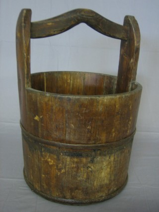 A reproduction wooden well bucket with wooden handle