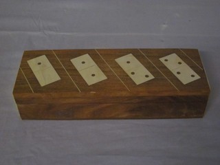 A set of hardwood and brass inlaid dominoes contained in a rectangular box with hinged lid