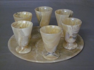 A circular polished onyx tray together with 6 goblets