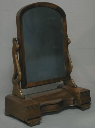A Victorian arched plate dressing table mirror contained in a  mahogany swing frame, the base fitted a glove box of serpentine  outline and flanked by 2 drawers, raised on scrolled feet 26"