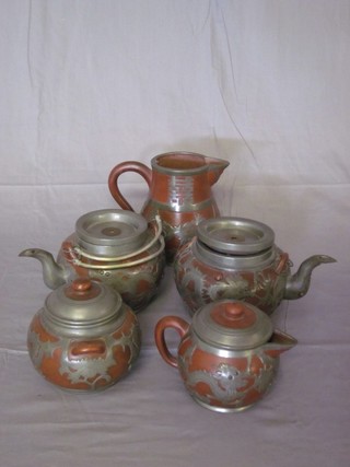 A 5 piece Tanware tea service with pewter mounts comprising 2 teapots , sugar bowl and cream jug together with a jug