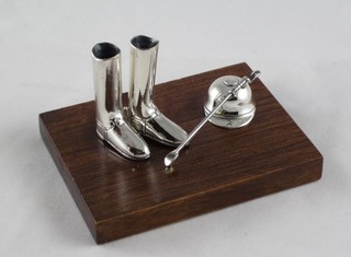A wooden and silver mounted paperweight in the form of pair of riding boots, jockey cap and whip