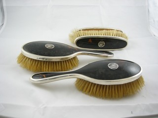 A 1920's silver and tortoiseshell 4 piece dressing table set comprising pair of hair brushes, pair of clothes brushes