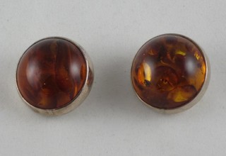 A pair of silver ear studs set amber