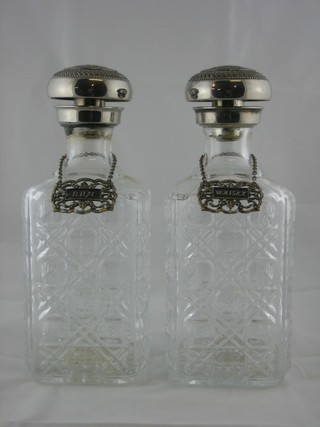 A pair of moulded glass decanters and stoppers with labels
