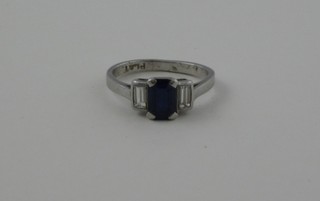 A lady's 1920's platinum dress ring set a sapphire supported by 2 baguette cut diamonds