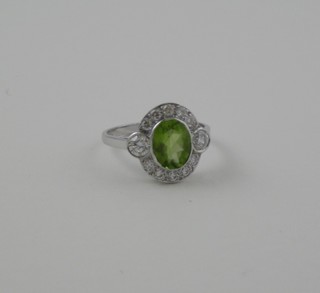 A lady's 18ct white gold dress ring set a peridot surrounded by  diamonds, approx 0.85ct