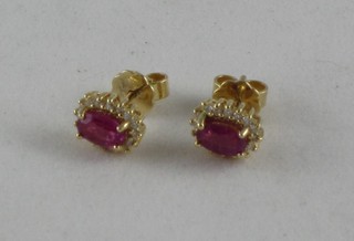 A pair of 18ct gold ear studs set rubies and diamonds