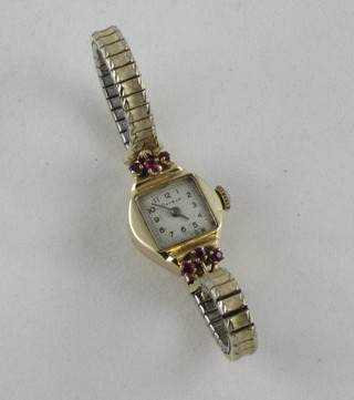 A lady's Geneva wristwatch contained in a gold and jewelled case