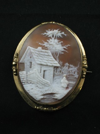 A shell carved cameo brooch decorated a house, contained in a gilt metal brooch mount