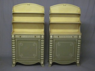 A handsome pair of Regency style painted bookcases fitted 3 shelves above a drawer and cupboard, with column decoration to  the sides and raised on splayed bracket feet 27"