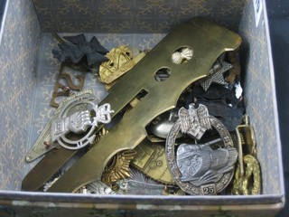 A brass button stick and a collection of various military badges