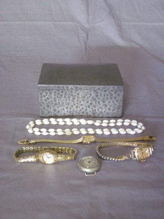 A planished pewter cigarette box with hinged lid, the base marked Talbot containing 3 ladies wristwatches, a small  collection of coins and costume jewellery