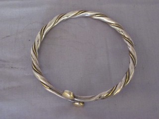 A silver and gilt metal torque type bangle