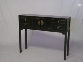 An Eastern black lacquered cabinet fitted cupboards flanked by 4 drawers, raised on square supports 39"