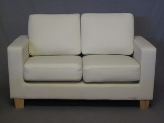 A 3 piece suite upholstered in white hide comprising 2 seat settee 63" and 2 matching armchairs