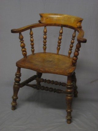 An elm Captain's chair with solid seat of serpentine outline, raised on turned supports