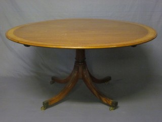 A circular Georgian style mahogany pedestal dining table with crossbanded top, raised on pillar and tripod base 57"
