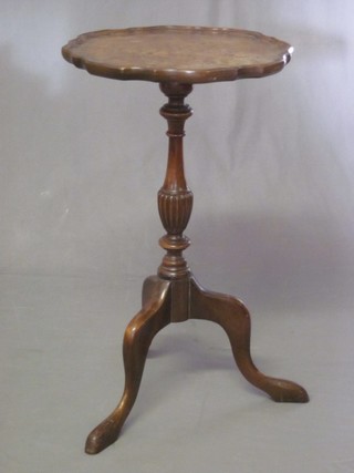 A circular walnut wine table with pie crust edge, raised on pillar and tripod supports 14"