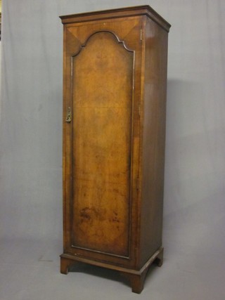 A Queen Anne style single walnut wardrobe with moulded cornice enclosed by an arched panelled door, raised on bracket feet 25"