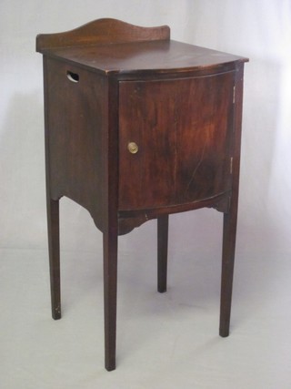 A Georgian style mahogany bow front bedside cabinet with raised back, enclosed by a panelled door, raised on square tapering supports 15"