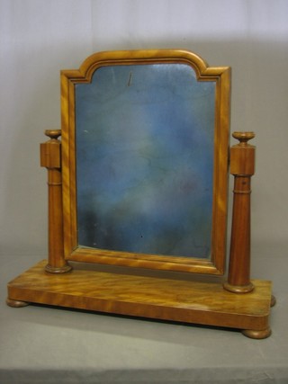 A Victorian plate dressing table mirror contained in a bleached walnut frame, raised on bun feet 26"