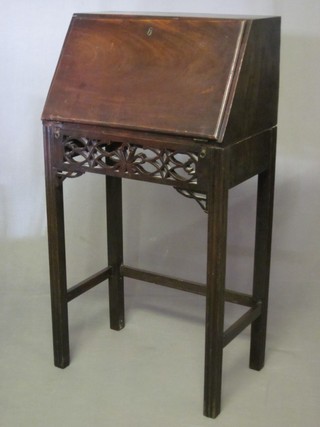 An 18th/19th Century Chippendale style student's mahogany bureau, the fall front revealing a well fitted stepped interior above a pierced frieze, raised on square supports 20"