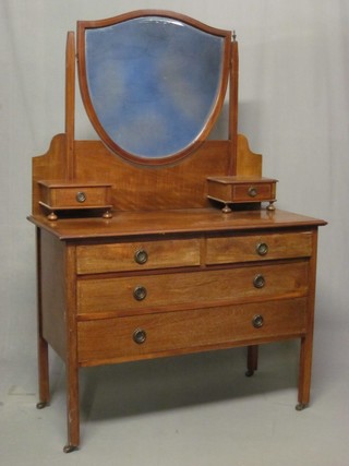 An Edwardian inlaid mahogany dressing chest with shield shaped mirror to the back, the base fitted 2 glove drawers above 2 short and 2 long drawers, raised on square tapering supports 42"