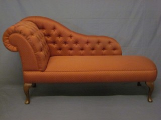 A 20th Century beech framed chaise longue upholstered in pink buttoned material, raised on cabriole supports 66"