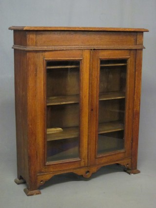 An Art Nouveau oak display cabinet fitted adjustable shelves, raised on bracket feet 35"