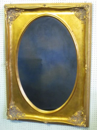 An oval plate wall mirror contained in a rectangular decorative gilt frame 44"