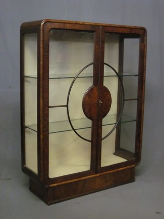 An Art Deco walnut display cabinet fitted shelves enclosed by astragal glazed panelled doors, 33"