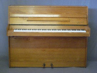 A modern iron framed upright piano forte by Danemann, contained in a teak case, retailed and purchased at Harrods