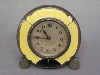 A 1930's travelling clock with silvered dial and Arabic numerals contained in a yellow enamelled case 3"