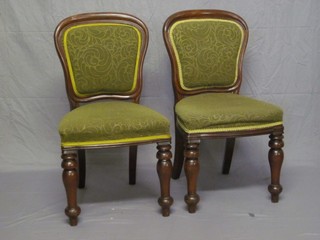 A set of 4 Victorian mahogany show frame dining chairs upholstered in green material and raised on turned supports