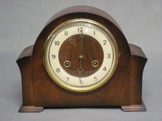 A 1940's striking mantel clock with enamelled dial and Arabic numerals contained in a walnut arch shaped case