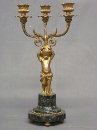 A gilt ormolu 3 light candelabra supported by a figure of a cherub and raised on a green marble base 15"